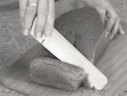 GIF of someone trying
to cut bread with a wedge of wood normally used to hold doors open